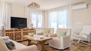 a living room with two chairs and a tv at VILLA Rübezahl in Benidorm
