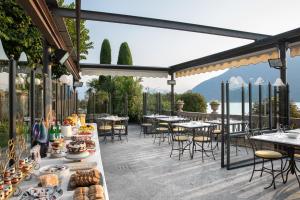 an outdoor patio with tables and chairs with food on it at Villa Maria Boutique Hotel in Cannobio