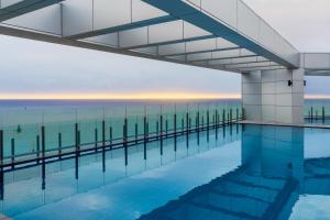 a swimming pool with the ocean in the background at Le Collective Sokcho Beach in Sokcho