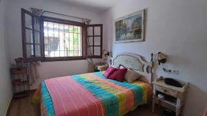a bedroom with a bed with a colorful blanket at Casa Blanca 42 – Piscina, BBQ y Wifi (5 pax) in Tossa de Mar +31 photos
