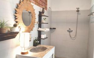 ein Badezimmer mit Waschbecken, Spiegel und Dusche in der Unterkunft The shortcut rooms in Canggu