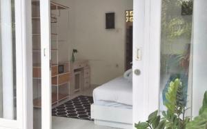 ein Zimmer mit einem Schlafzimmer mit einem Bett und einem Fenster in der Unterkunft The shortcut rooms in Canggu