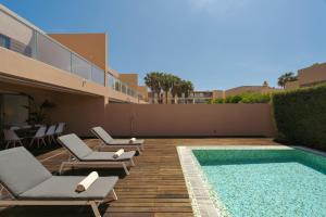 un patio con sedie a sdraio e una piscina di Salgados Premium Beach Villa by DA'Home ad Albufeira