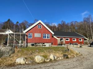 a red barn with white windows on a house at Lysefjorden og Prekestolen Unik og koselig leilighet i stallbygning in Sandnes