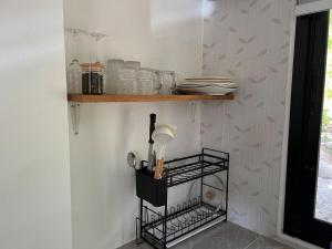 a kitchen with a shelf with dishes and utensils at Sunset Hut Haad Yao in Haad Yao