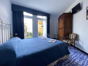 a bedroom with a blue bed and a window at Villa Margherita in Levanto