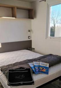 a bed with two boxes of cat food and a window at Camping 3 étoiles - Parc aquatique - ccaehgc in Déols