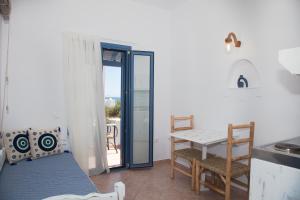 a room with a kitchen and a table and a table and chairs at Aquarius Village Agistri in Skala