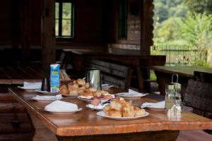 a wooden table with plates of food on it at Rafting Camp Tara Center Tri Vodenice in Bastasi