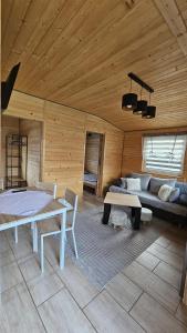 a room with a bed and a couch and a table at Domki u Ewci - Domki całoroczne in Uherce Mineralne