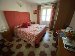 a bedroom with a bed with a red headboard at Villa Margherita in Levanto