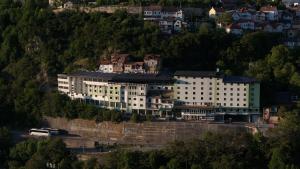 un grande edificio bianco in cima a una montagna di Hotel Saraj a Sarajevo