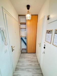 an empty hallway with a door and an open refrigerator at Soh Rent Strasbourg Wifi Terrasse St Aloise in Strasbourg