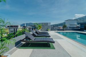 a row of benches sitting next to a swimming pool at Di Yana Patong in Patong Beach
