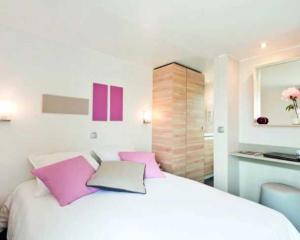 Plobannalec-LesconilCamping 3 étoiles - efdbeb的卧室配有带粉红色枕头的大型白色床 更多79张照片