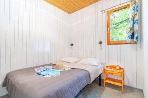 a bedroom with a bed with a hat on it at Camping Le Hameau du Petit Lay in Mouchamps +32 photos