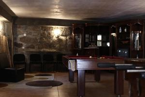 una mesa de billar en una habitación con una pared de piedra en Villas da Quintã, en Cabeceiras de Basto