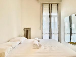 a white bedroom with a bed with towels on it at 3 Camere Terrazzo e Posto Auto - Praga 36 in Rimini