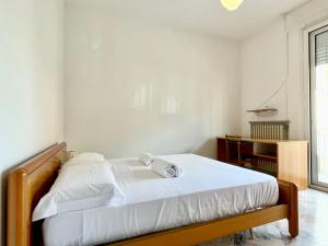 a bedroom with a bed with white sheets and a window at 3 Camere Terrazzo e Posto Auto - Praga 36 in Rimini