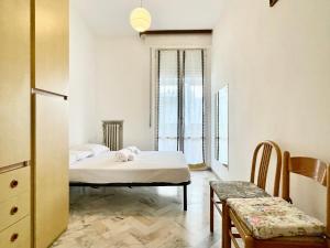 a bedroom with two beds and a table and a chair at 3 Camere Terrazzo e Posto Auto - Praga 36 in Rimini +14 photos