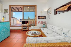 a living room with a couch and a table at Marineledda la terrazza sul golfo in Marinella