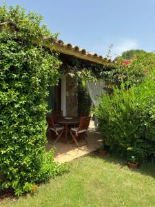 a patio with a table and chairs in a garden at Villettadaisy, Chia in Chia