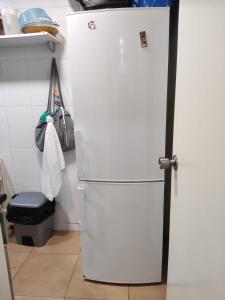 a white refrigerator in a kitchen next to a stool at Hab Moderna A 20 Minutos del Centro de Barcelona in Santa Coloma de Gramanet +81 photos