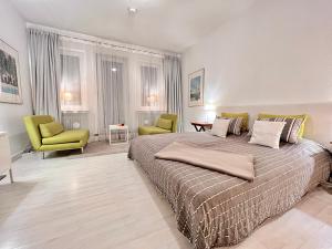 ブレーメンにあるBremen City Apartmentの大きなベッドと椅子2脚のある寝室