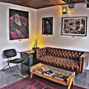 a living room with a brown leather couch and a table at otto7senses in Haifa +27 photos