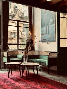 a living room with a green couch and two tables at otto7senses in Haifa