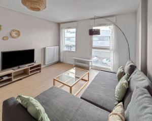 a living room with a couch and a flat screen tv at Appartement confort et calme, proche commerces in Créteil