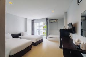 a hotel room with two beds and a television at Di Yana Patong in Patong Beach +75 photos