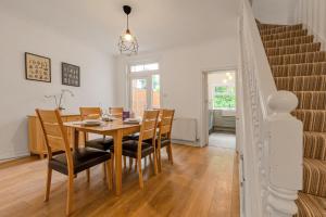 a dining room with a wooden table and chairs at Gorgeous 2BR plus Victorian home with Parking and Garden in London