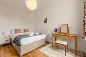 a bedroom with a bed and a desk and a mirror at Gorgeous 2BR plus Victorian home with Parking and Garden in London