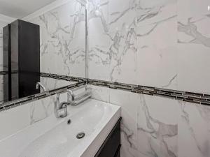 a white bathroom with a sink and a mirror at Appartement confort et calme, proche commerces in Créteil