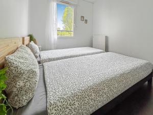 a bedroom with two beds and a window at Appartement confort et calme, proche commerces in Créteil