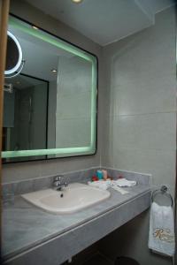 a bathroom with a sink and a large mirror at Rewaya Majestic Resort in Hurghada