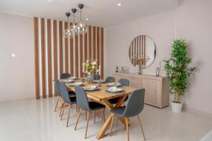 a dining room with a table and chairs and a mirror at Seascape Villa Marine in Fujairah