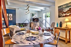 ein Esszimmer mit Tisch und Stühlen und einem Kamin in der Unterkunft LocaLise - M20B - Ocean Lodge - Maison avec jardin clos - terrasse - plage à 400m - wifi inclus - draps inclus - animaux bienvenus in Le Guilvinec