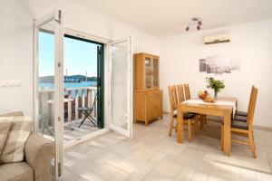 a living room with a table and a view of the ocean at Sun Spalato Maslinica in Maslinica