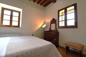 a bedroom with a bed and a dresser and two windows at The Rose in Colle Malamerenda