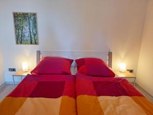 a bed with a colorful comforter and two side tables at Gemütliche Ferienwohnung am Nationalpark Harz mit Parkplatz am Haus in Altenau