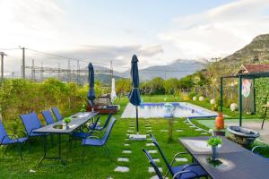 a patio with tables and chairs next to a pool at Apartment Merona with Swimming Pool in Trebinje