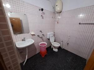 a bathroom with a sink and a toilet and a mirror at Ushodaya Resorts in Araku