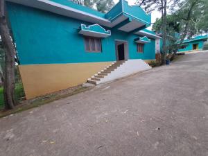 a blue house with a driveway in front of it at Ushodaya Resorts in Araku