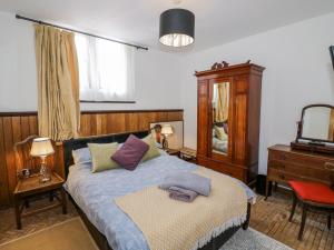 a bedroom with a bed and a dresser and a mirror at Talbot Lodge in Stafford