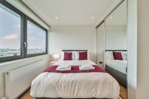 a bedroom with a large bed and two windows at Roomspace Serviced Apartments -Oasis Way in London