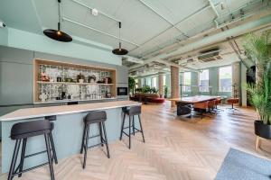 an office with a bar with stools and tables at Roomspace Serviced Apartments -Oasis Way in London