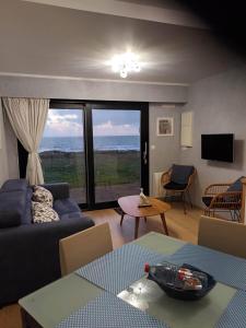 a living room with a couch and a view of the ocean at RESIDENCE LA NATURELLE Studio in Wimereux