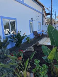 una casa azul con un patio con plantas en Paderne Village House, en Paderne